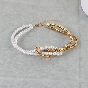 Detail of layered necklace with faux pearls, golden beads and adjustable lobster clasp