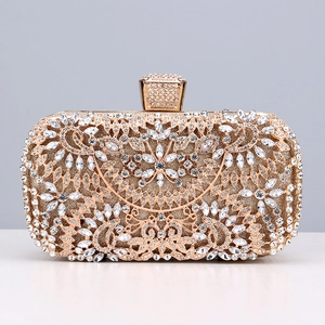 Macro shot of gold evening clutch featuring intricate rhinestone floral hollow patterns