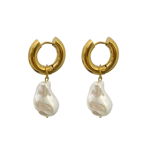 Fashionable gold hoop earrings with irregular baroque pearls on a white background