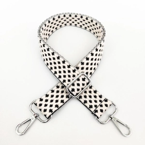 Detail of adjustable black and white houndstooth canvas wide strap with silver hooks