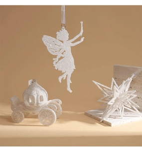 Detail of glittery Christmas tree ornaments with fairy star and pumpkin carriage icons