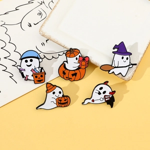 Close-up of five Halloween enamel pins featuring cute ghost and pumpkin motifs on a tray