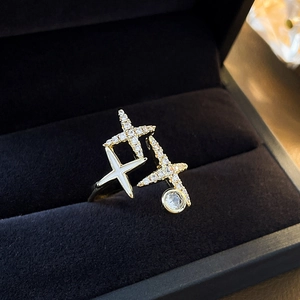 Detailed close-up of gold plated star ring with zircons in a navy blue velvet jewelry box