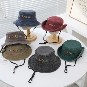 Detail of embroidered construction vehicles on colorful cotton kids bucket hats with chin straps