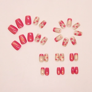 Detail of cat-eye heart press-on nails in rose pink with gold glitter and French tips