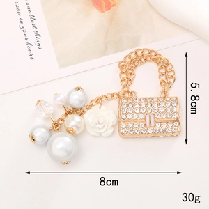 Detailaufnahme von funkelndem Strass-Handtaschenanhänger mit Perlen und Harzrose