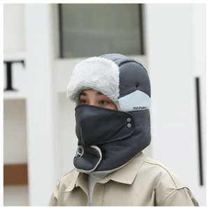 Detailed side view of a model wearing a thick grey winter trapper hat with protective mask