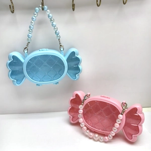 Dettaglio delle borse portaoggetti a forma di caramella con manici di perle rosa e blu