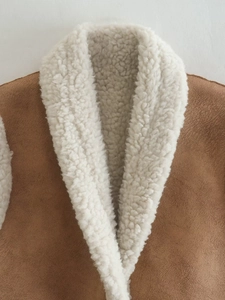 Close-up of brown faux suede vest collar with soft cream sherpa faux shearling lining