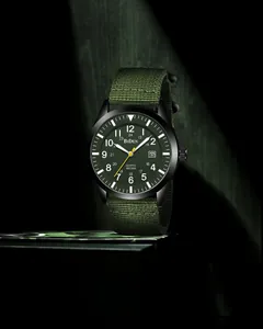 Military quartz watch with army green nylon strap and black metal case in dramatic lighting
