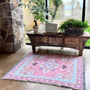 Close-up of bohemian woven blanket with vibrant floral patterns and fringe details