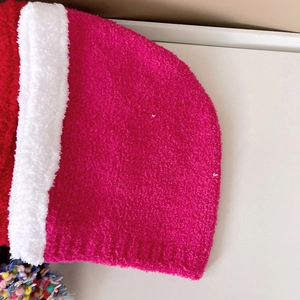 Macro detail of plush knit hat with colorful pom-pom trim and soft fleece texture