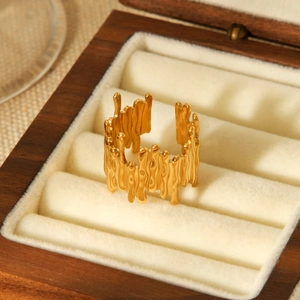 Detailed view of 18K gold plated open ring with lava texture in a luxury wooden box