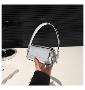 Close-up of the silver mirror finish texture on a retro stylish handbag with metallic shine