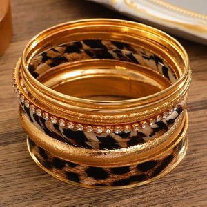 Close-up of vintage leopard print bangles with gold floral carvings and rhinestone inlay