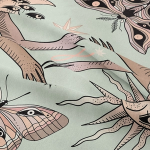 Detail of surreal moth and eye print on bohemian mandala tapestry fabric