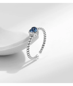 Detail of S925 sterling silver twisted ring band with a heart-shaped blue gemstone