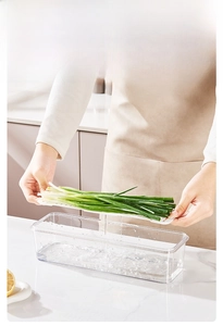 Detail showing the white drainage tray lifting from a transparent kitchen container