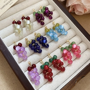 Detailed macro view of resin grape cluster tassel earrings in various vibrant colors