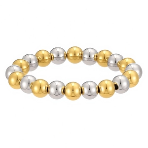 Close-up of gold and silver tone stainless steel round bead elastic bracelet with polished finish
