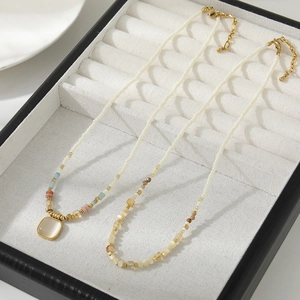 Handmade beaded necklace set with natural colorful stones and white milk beads on tray
