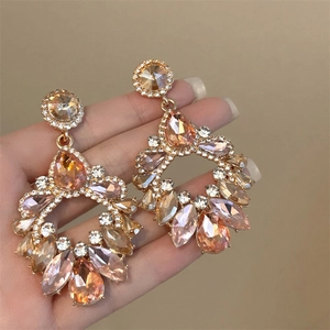 Detail of luxury chandelier earrings with champagne crystals and golden tassels