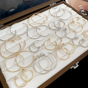 Various sizes of gold and silver polished hoop earrings displayed in a velvet jewelry box