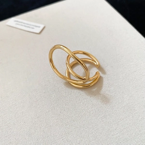 Detailed view of golden multi-layer geometric double ring on a textured surface