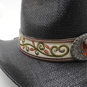 Détail d'un chapeau de cowboy en paille avec broderie de vigne et boucle ornée de gemme