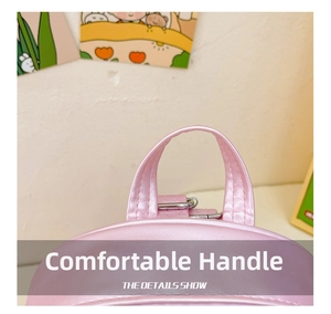 Detail view of the pink pearlescent carry handle with silver metal buckles on the backpack