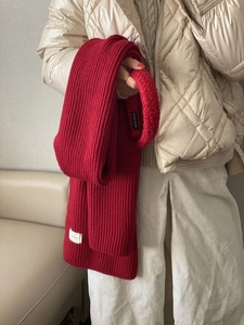 Close-up of thick red knitted scarf texture showing soft wool-like yarn details