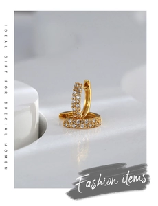 Detail of gold plated brass hoop earrings featuring micro paved white cubic zirconia