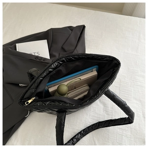 Vue détaillée de l'intérieur spacieux du grand sac fourre-tout noir matelassé avec objets