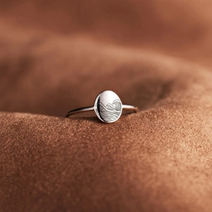S925 Sterling Silber Wellenring mit gravierter ovaler Fläche auf braunem Stoff