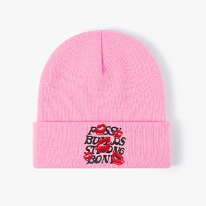 Pink knit beanie with red lip embroidery and bold black letter typography design