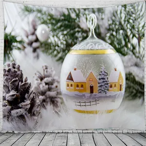 Détail d'une tapisserie de Noël montrant une boule de verre avec maison enneigée sur mur blanc