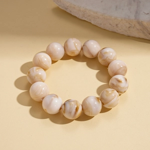 Detail of warm beige resin beads bracelet with brown sand textures on stone decor