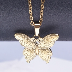 Gros plan d'un pendentif papillon doré avec motifs évidés complexes et gravure fine