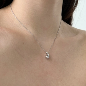 Detailed view of silver water drop pendant necklace on model collarbone area