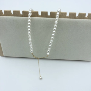 Detail of adjustable 14k gold-filled chain with high-luster pearls and a pendant