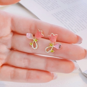 Detailed close-up of pink tulip earrings with enamel petals and sparkling crystal accents
