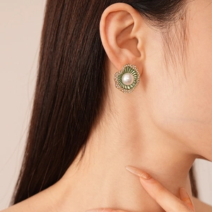 Gros plan de boucles d'oreilles perles vintage avec détails verts sur le mannequin