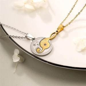 Detail of silver musical note pendant and gold treble clef puzzle necklace with rhinestones