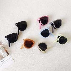 Foldable kids sunglasses in assorted colors shown in a flat lay arrangement