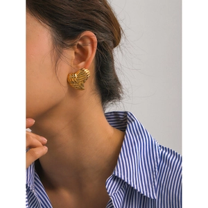 Textured 18k gold plated stainless steel heart stud earrings worn by a model