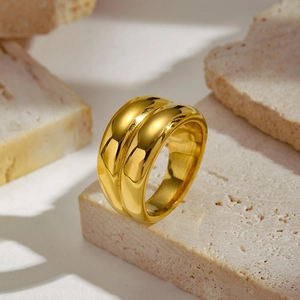 Close-up of gold double-ring design with thick metallic texture on natural stone background
