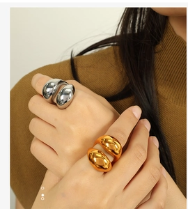Close-up of sculptural 18K gold and silver polished spherical rings on a model