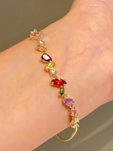 Close-up of 18k gold plated bracelet with colorful pear-cut zircon stones and slider clasp