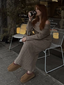 Detail of the brown ribbed knit texture and off-the-shoulder design of the long dress
