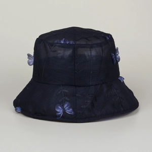 Détail d'un chapeau cloche en dentelle bleu marine avec broderie et papillons 3D